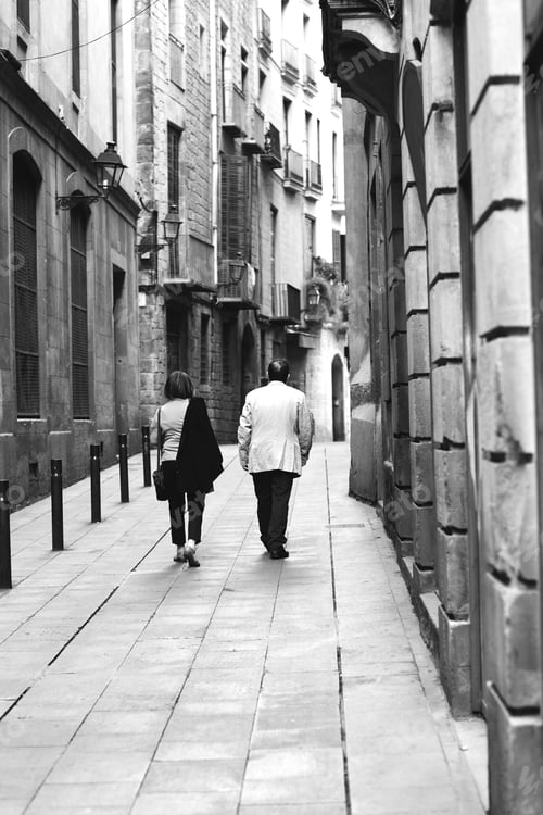 Preview: An Older Couple Walking In The Narrow Streets. Image In Black And White.