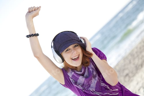 Preview: Portrait Of Red-Haired Girl In Cap With Headphone On The Beach.