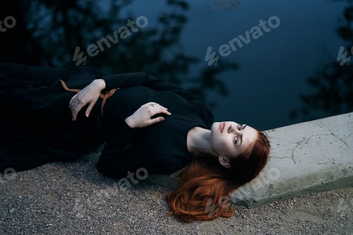 Preview: A Woman In A Black Dress Lies Near A Lake In The Park