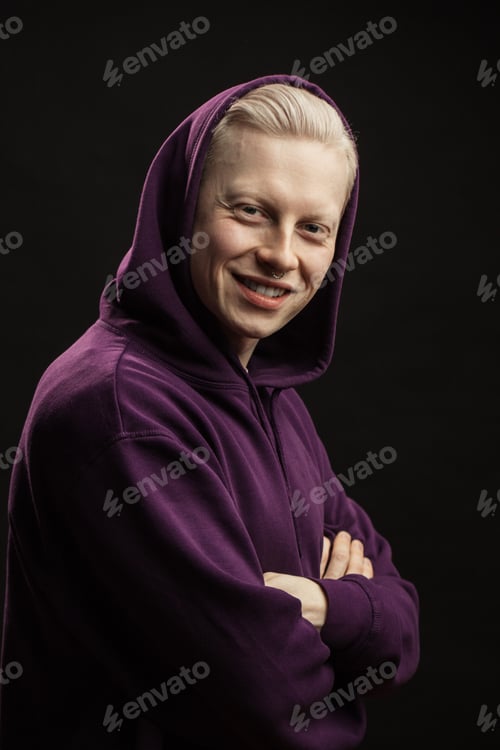 Preview: Headshot Of Young Happy Blonde Male In Purple Sportswear With Hood Over Head Looking At Camera