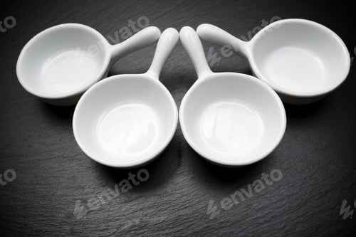 Preview: Four Small White Spoons On A Table Slate