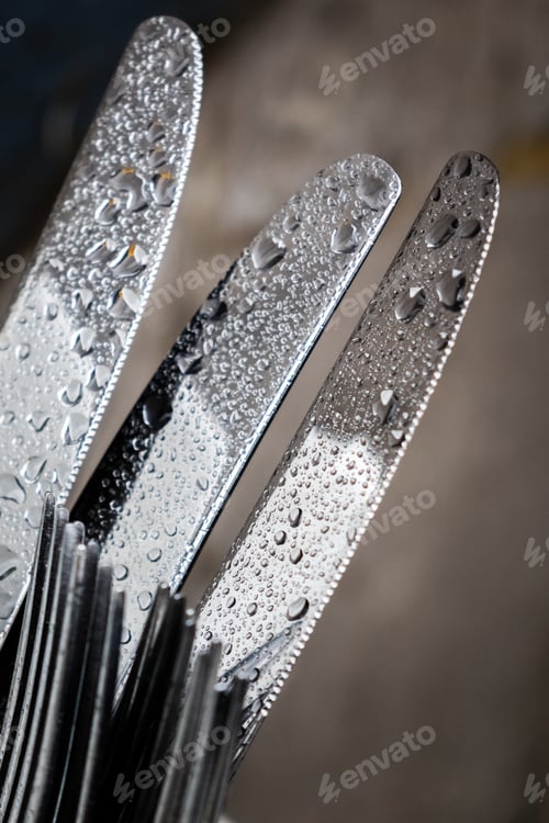 Preview: Wet Cutlery Left In A Bowl On A Table Outside Restaurant