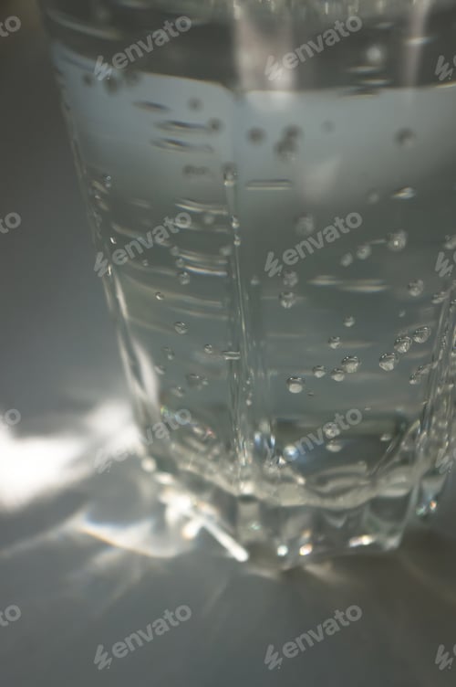 Preview: Transparent Faceted Glass With Bubbly Water In The Sun Refracted Light