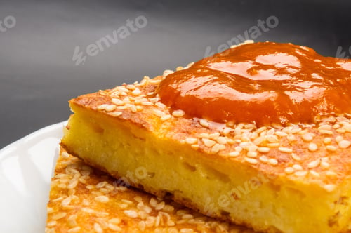 Preview: Slice Of Cheesecake With Sesame Seeds And Apricot Jam On A Black Background
