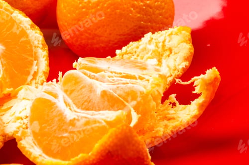 Preview: Tangerines, Peeled Tangerine And Tangerine Slices In A Red Plate On Black Background