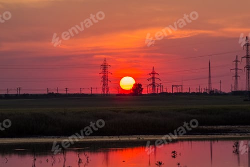 Preview: Beautiful, Dramatic, Colorful Clouds And Sky At Sunset. Electrical Wires And Stakes And Water