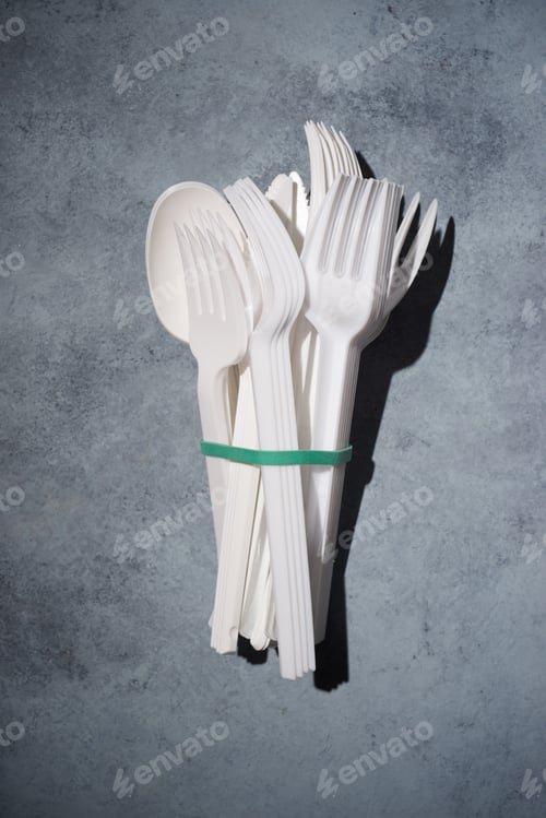 Preview: Disposable Plastic Cutlery On A Stone Table.