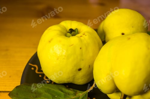 Preview: Large Yellow Quince Fruits On A Ceramic Plate, With Anise, Cinnamon, And Walnuts