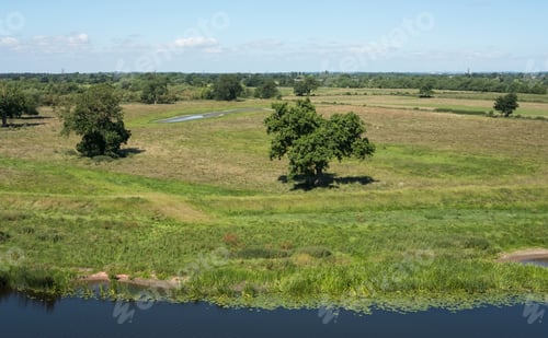 Preview: Flat Countryside Landscape With Trees And A River