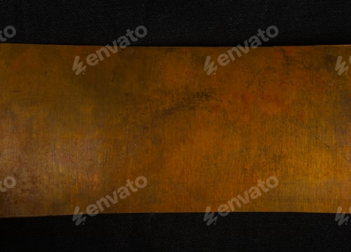 Preview: Aged Copper Plate On Black Cloth, Old Worn Metal Background.