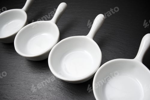 Preview: Four Small White Spoons On A Table Slate