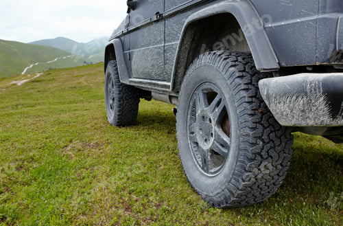Preview: A Black Offroad All Terrain Vehicle On A Green Pasture In The Mountains