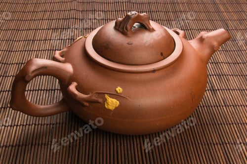 Preview: Brown Chinese Teapot Of Yixing Clay With Traditional Ornament On Bamboo Mat