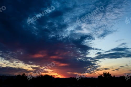 Preview: Dramatic Red And Black Clouds In Sunset Over City Rooftops