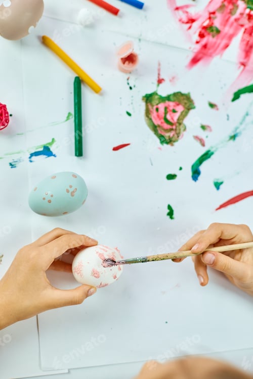 Preview: Unrecognizable Little Girl Painting, Drawing With Brush Eggs At Home. Child Preparing For Easter
