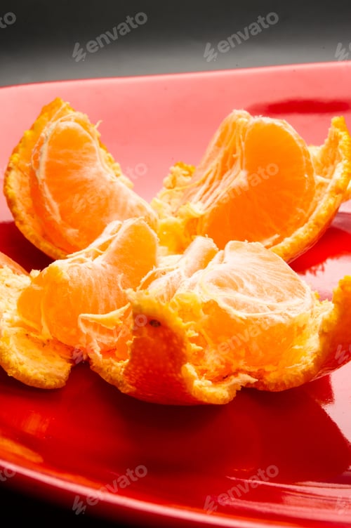 Preview: Tangerines, Peeled Tangerine And Tangerine Slices In A Red Plate On Black Background