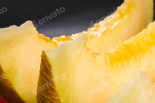 Preview: Slices Of Ripe Juicy Melon In Red Plate On Black Background