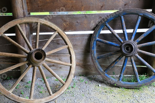 Preview: Two Old Wooden Wheels On Wooden Wall Background