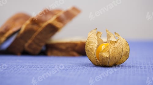 Preview: Physalis Peruviana Fruit And Sweet Bread Slices With Blue Table Cloth