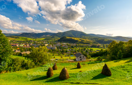 Preview: Beautiful Rural Landscape In Mountains. Haystacks On The Grassy Hills. Village At The Foot Of The