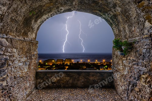 Preview: Scenic Rock Arch Balcony Overlooking A Lightning Storm Over The Sea