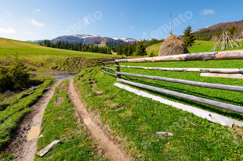 Preview: Beautiful Carpathian Countryside In Springtime. Dirt Road Down The Hill And Haystack Behind The