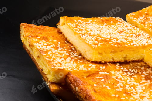 Preview: Slice Of Cheesecake With Sesame Seeds On A Black Background