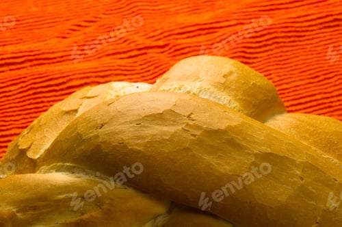 Preview: Fresh Braided Loaf Of White Wheat Bread On An Orange Napkin