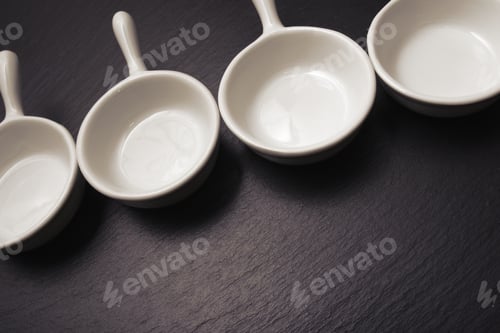 Preview: Four Small White Spoons On A Table Slate