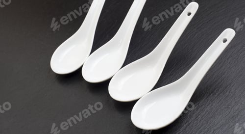 Preview: Four Small White Spoons On A Table Slate