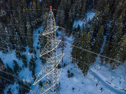 Preview: Aerial View Of Power Line Pylon In Alpine Area In Winter. Snow Covered Mountain And Fir Trees
