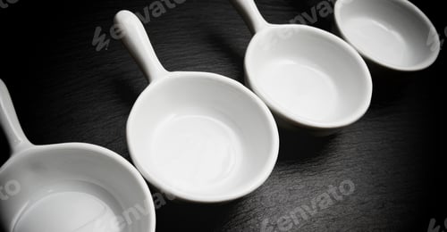 Preview: Four Small White Spoons On A Table Slate