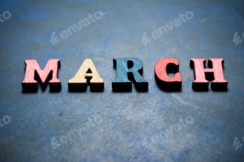 Visualização: Palavra de março em uma mesa azul.