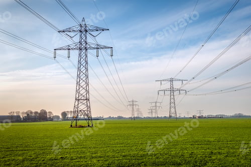 Preview: Two Seemingly Endless Long Rows Of Electricity Pylons In A Dutch Polder Meadow With Fresh Green