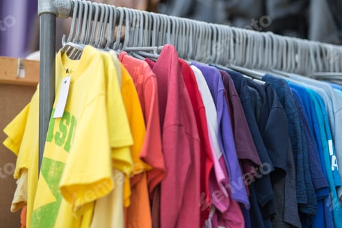 Preview: Group Of Coloured T-Shirts For Sale Hanging On A Garment Holder.