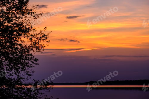 Preview: Colorful Sunset By The Lake With Tree Silhouettes And Red Sky In Background