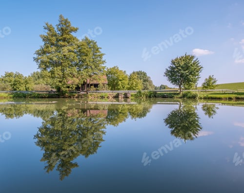 Preview: A Perfect Reflection On The Road With Cottages, Trees And The Road.
