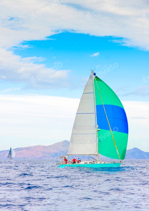 Preview: Sailing Boat With A Green - Blue Spinnaker During A Regatta Out Of Poros Island In Greece