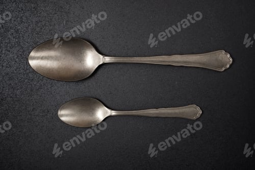Preview: Metal Spoons On A Black Table.