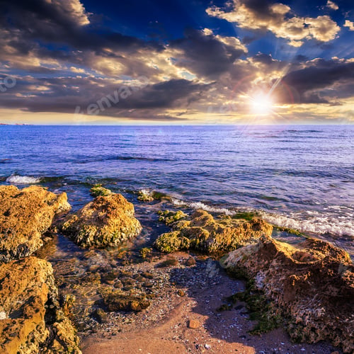 Preview: Sea Wave Attacks The Boulders And Is Broken About Them At Sunset