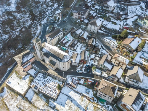 Preview: Arial View Of Village In Swiss Mountains In Ticino In Winter With Snow Covered Roofs