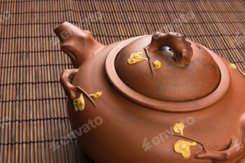 Preview: Brown Chinese Teapot Of Yixing Clay With Traditional Ornament On Bamboo Mat