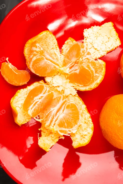 Preview: Tangerines, Peeled Tangerine And Tangerine Slices In A Red Plate On Black Background