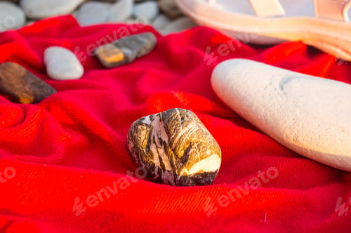 Preview: Red Towel And Stones On Pebble Beach, Sunset