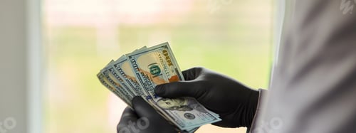 Preview: Man Holding Money Dollars In Hand In Black Medical Gloves. Coronavirus Crisis. Save Money.