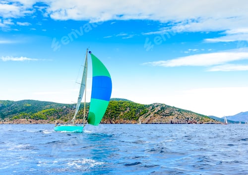 Preview: Sailing Boat With A Green - Blue Spinnaker During A Regatta Out Of Poros Island In Greece