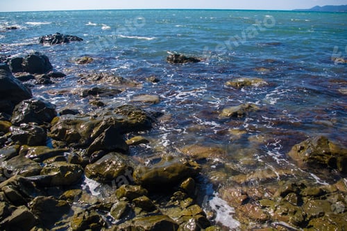 Preview: Rocky Sea Shore With Pebble Beach, Transparent Waves With Foam, On A Warm Summer Day