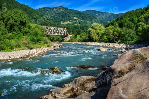 Preview: Iron Bridge And A Giant Stone On The Opposite Side Of The River In The Mountains