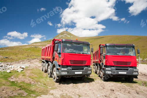 Preview: Two Large Red Dump Trucks At Construction Site, In A Sunny Summer Day