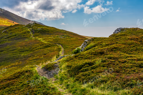 Preview: Tourists Curve Path Up The Hill To The Top. Beautiful Grassy Mountain Meadows With Rocks On Humps